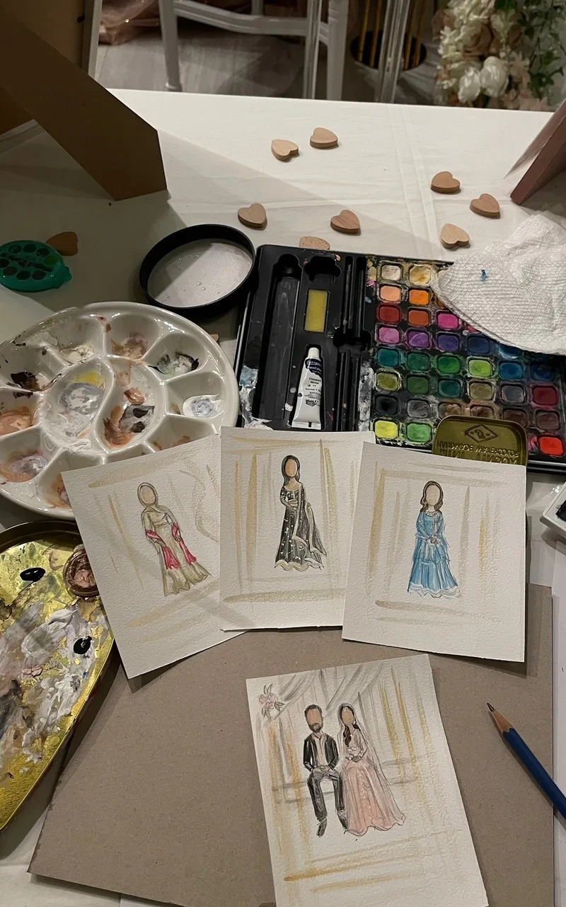 Watercolour palette beside a finished live guest portrait