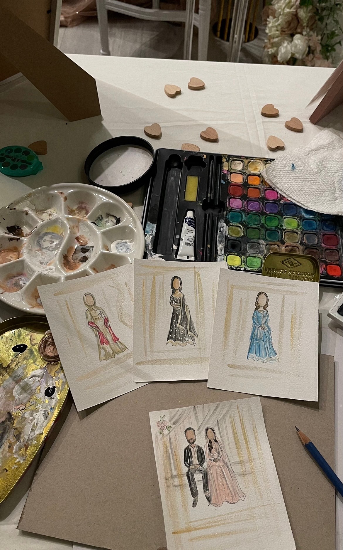 A Lil T Keys Studio paint table with watercolor palette and finished illustrations