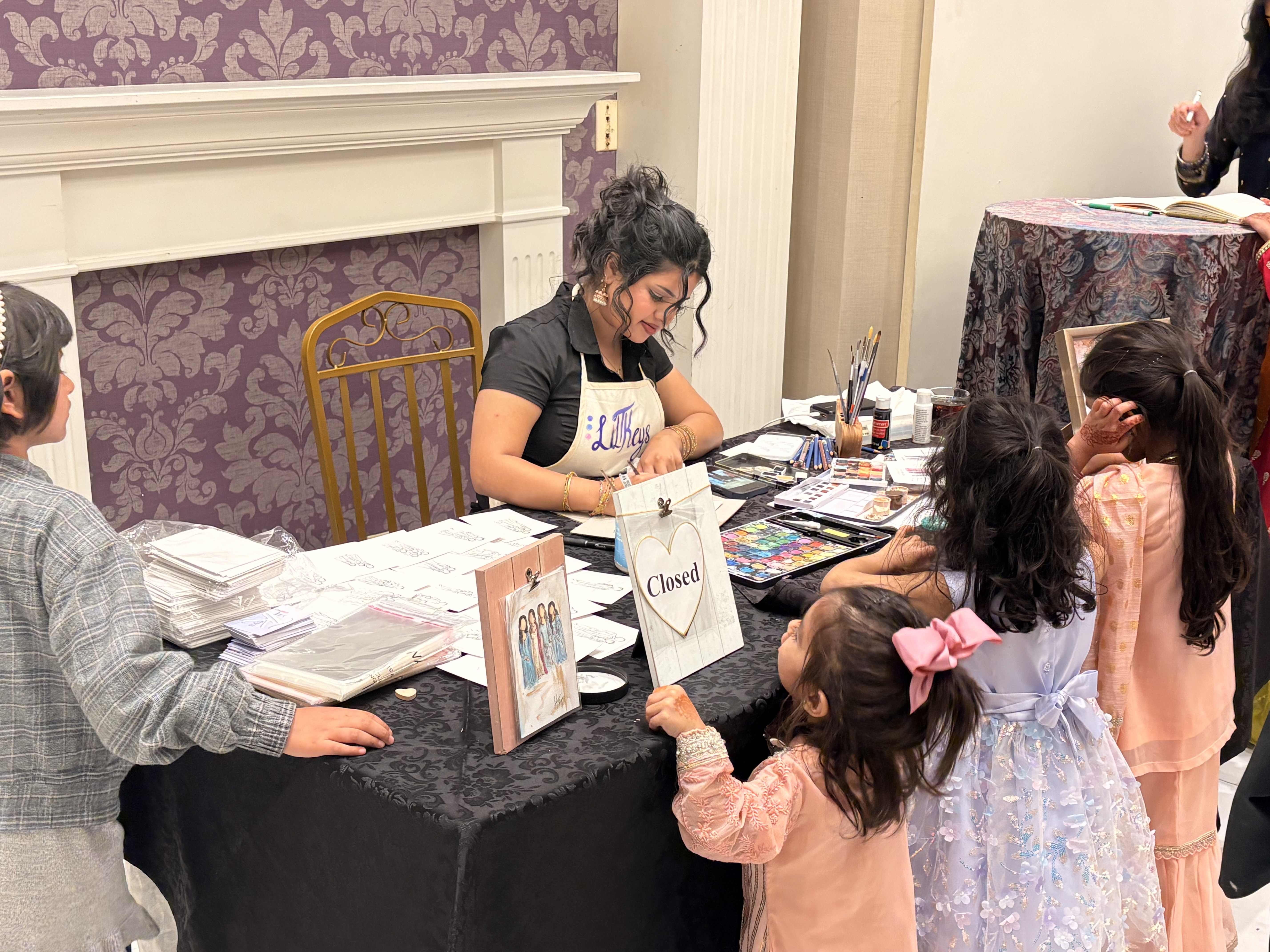 Talia painting live with guests nearby