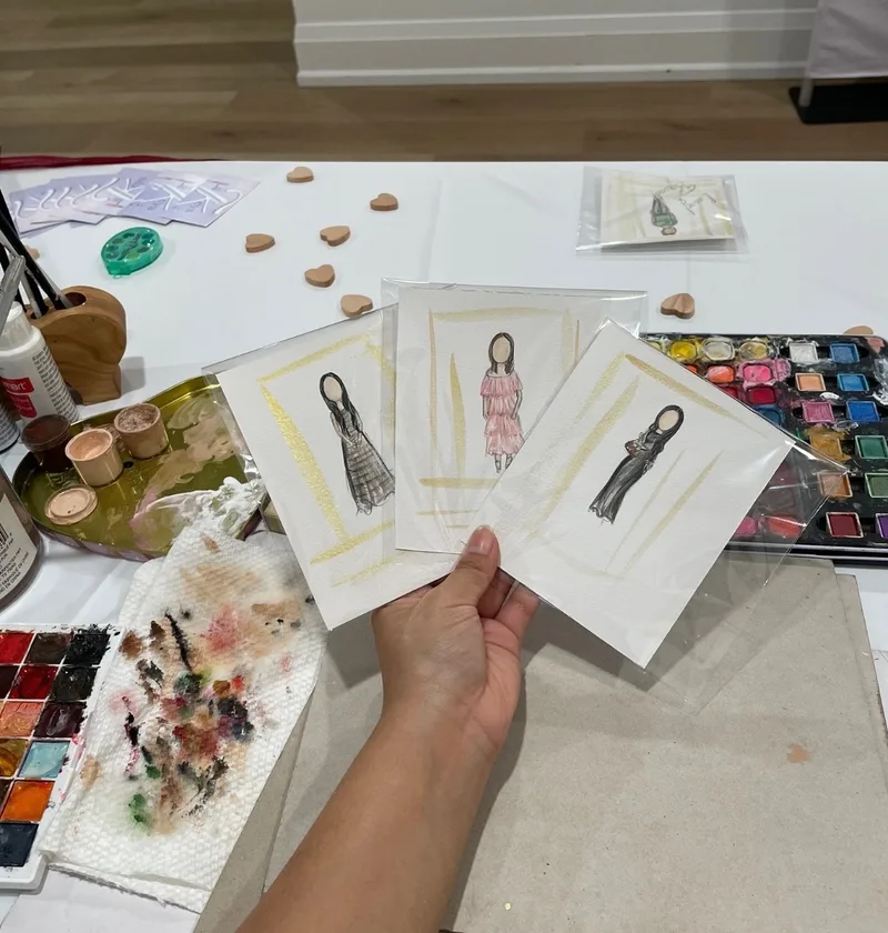 Three finished guest illustrations presented at Talia's art table